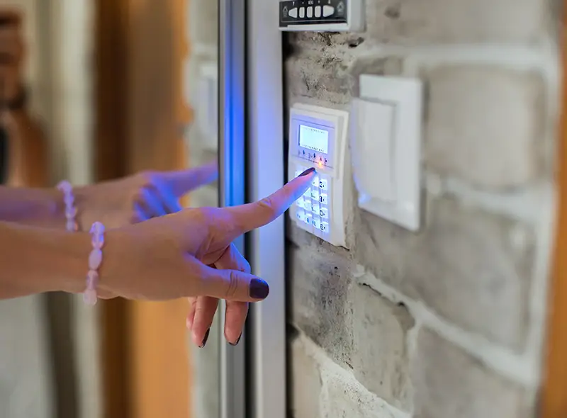 Une femme utilisant le clavier pour gérer son alarme